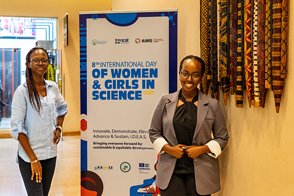 Two women in front of event sign