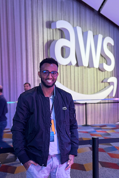 Berhanu in front of AWS sign