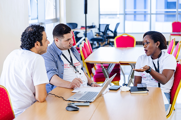 Three people talking at a table