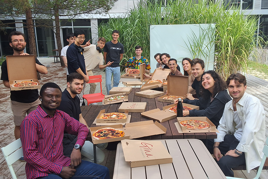 A group of diverse individuals enjoying pizza together outdoors in a casual setting.
