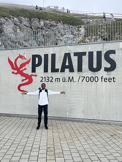 The student outside in front of a PIlatus sign