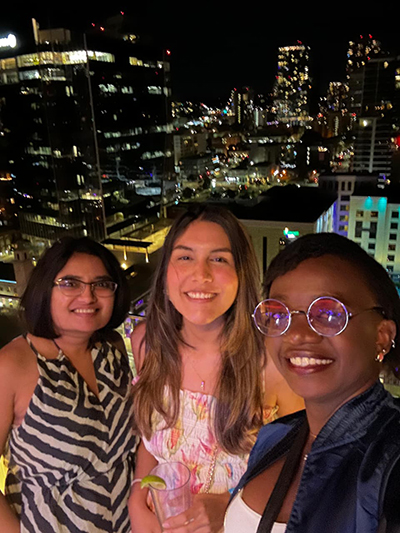 Three women with the cityscape behind them