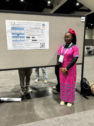 A woman in front of her poster