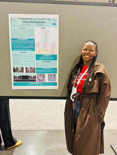 A woman in front of her poster