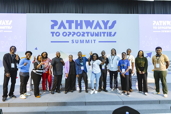 A group photo of about fifteen people up on stage, some doing silly poses
