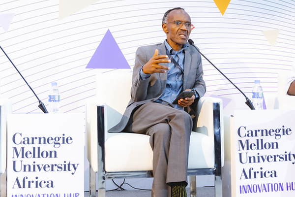 A man sitting in a chair and talking on a panel session