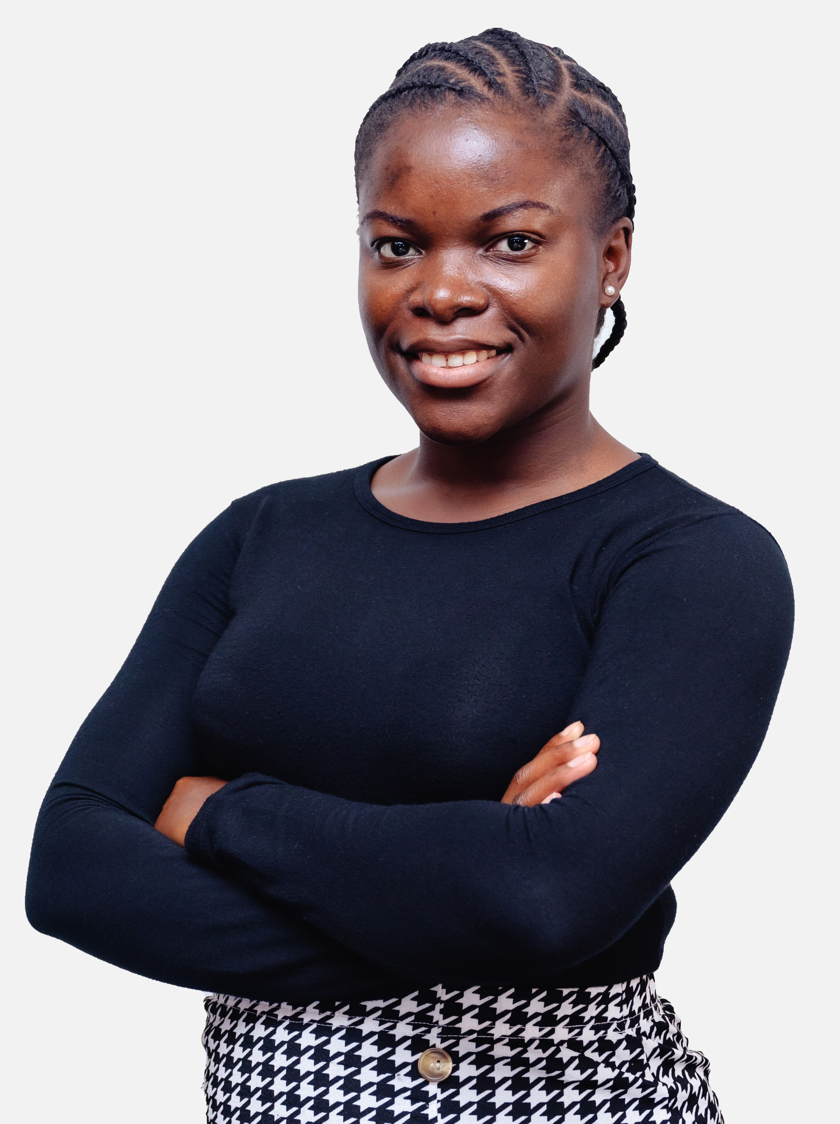 Studio portrait of a smiling woman with braided hair, arms crossed, wearing a black top and a patterned skirt against a white background.