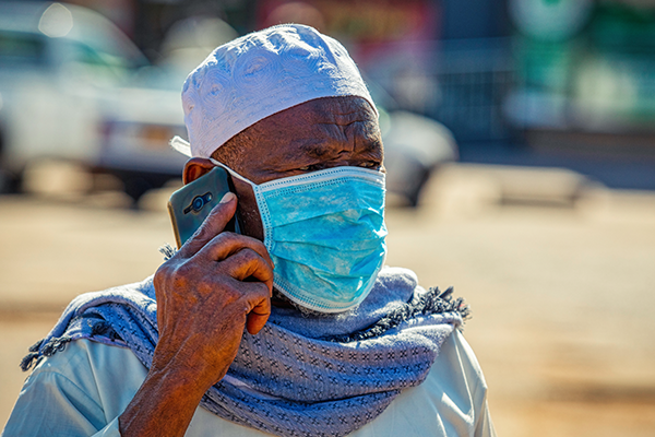 Man on phone in Africa wearing mask