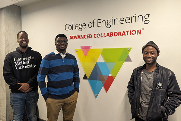 Three students with Advanced Collaboration sign.