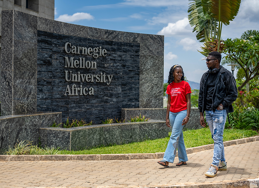Two students walking by a CMU-Africa sign